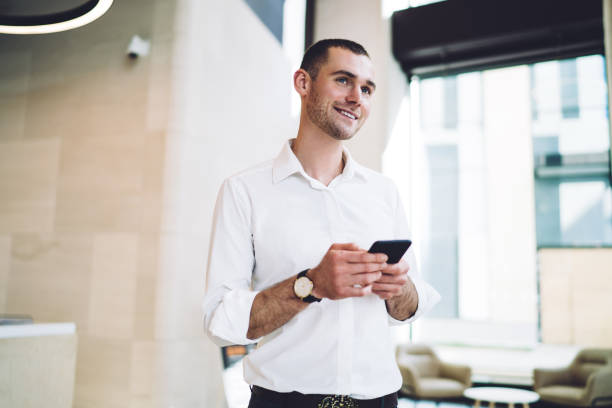 istock Dreamy man messaging with mobile in office 1407355834