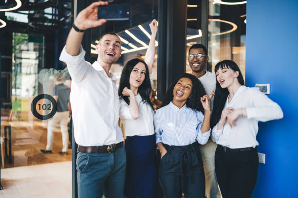 istock Cheerful colleagues taking selfie by smartphone 1407355845