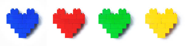 Set of four Colored Hearts from plastic building block isolated on white background, red, blue, green, yellow figure plastic blocks, shapes heart of child construction. Toys, games and recreation