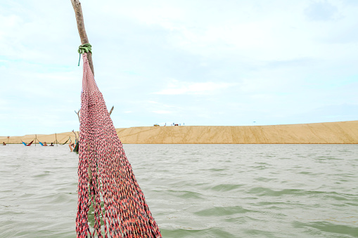 Resting in a hammock on the edge of the tatajuba lagoon in jericoacoara ceará brazil. Traditional hammock in the sea in Jeri. Rest hammock concept. vacation rest concept.
