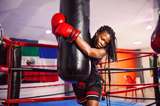 Strong black woman boxing in the gym
