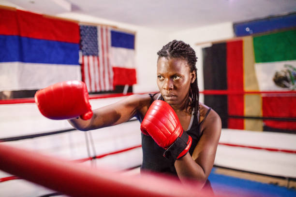 Female fighter with red gloves in a boxing ring