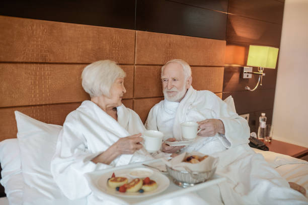 istock A senior happy couple enjoying breakfast while staying in bed 1407365024