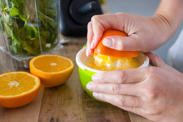 Squeezing oranges for smoothie stock photo