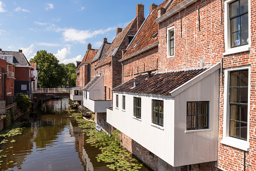 Newly built homes in traditional style alongside canal. Panorama image shot in The Netherlands. 