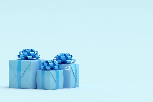 Two gift boxes wrapped in kraft paper and tied with ribbon on blue background decorated with confetti. Top view, gift idea for him and her.