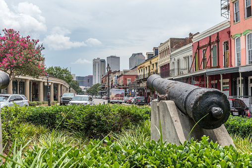 New Orleans, LA, USA - June 27, 2022: View of old cannons near by the traditional and historic architecture of the French Quarter in New Orleans. The French Quarter, also known as the Vieux Carré, is the oldest neighborhood in the city of New Orleans.
