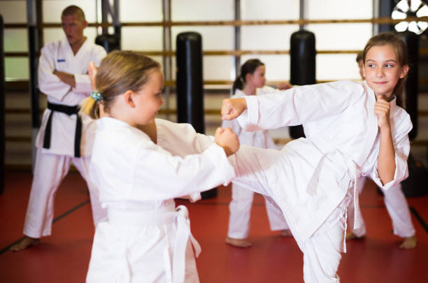 istock Children working in pair mastering new karate moves during group class 1407370494