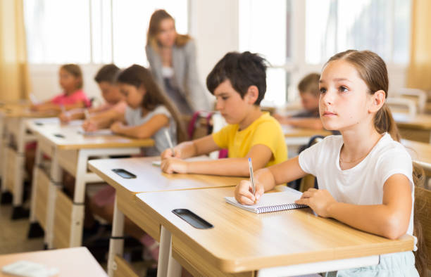 istock Schoolgirl sitting in classroom during lesson in elementary school 1407371924