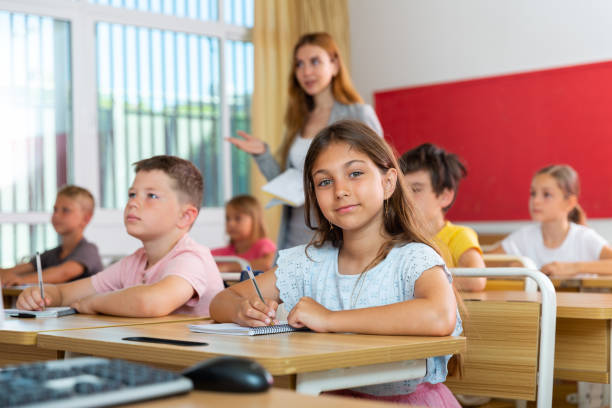istock Schoolgirl sitting in classroom during lesson in elementary school 1407371929
