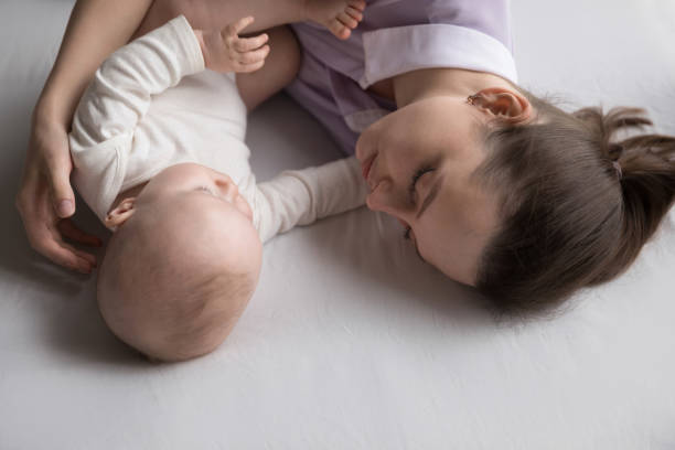 istock Serene mother and newborn sleeping on bed, above closeup view 1407372045