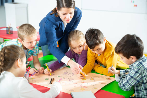 istock Kids with teacher playing educational tabletop game 1407372895
