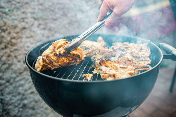 istock man chef cooking chicken meat on grill outdoor 1407378812
