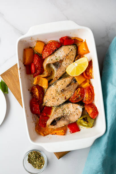 istock Overhead view of baking fish with tomatoes in dish 1407378978