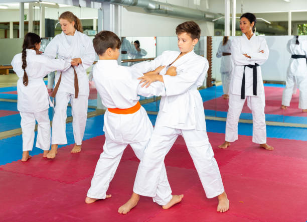 niñas y niños sparring durante el entrenamiento de karate - judo fotografías e imágenes de stock