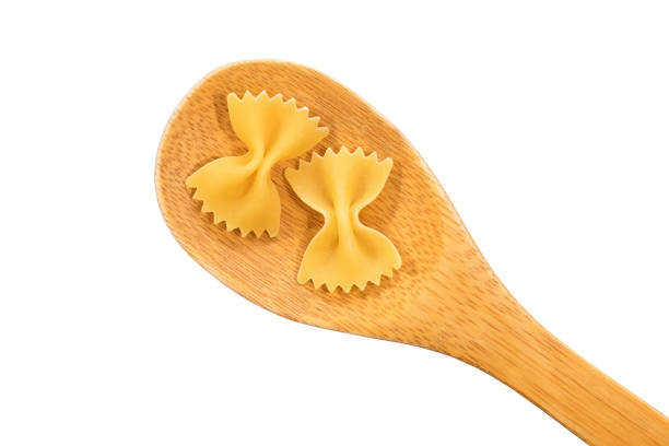 Wooden spoon with pasta isolated on white background. Top view