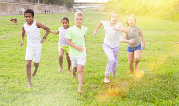 istock Barefoot kids running on green grass 1407380623