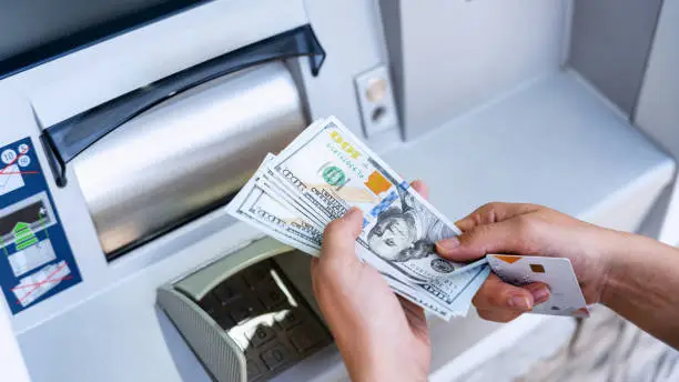 Photo of Atm machine money cash. Woman withdraw money bill. Holding american hundred dollar cash. Bank credit card and dollar bill.