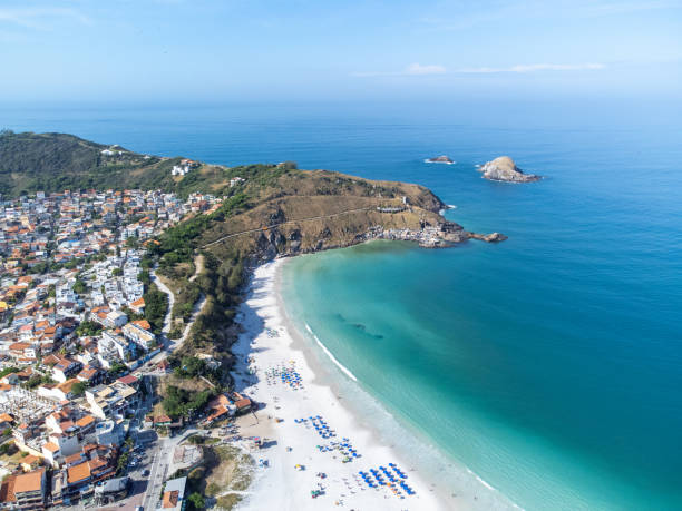Amazing drone view of paradise beach with fishing boats, Arraial do Cabo, Rio de Janeiro, Brazil Wonderful coast of the Atlantic Ocean in the midst of nature, mountains, forests and a small coastal town. Drone aerial view. Arraial do Cabo, Rio de Janeiro, Brazil arraial do cabo stock pictures, royalty-free photos & images