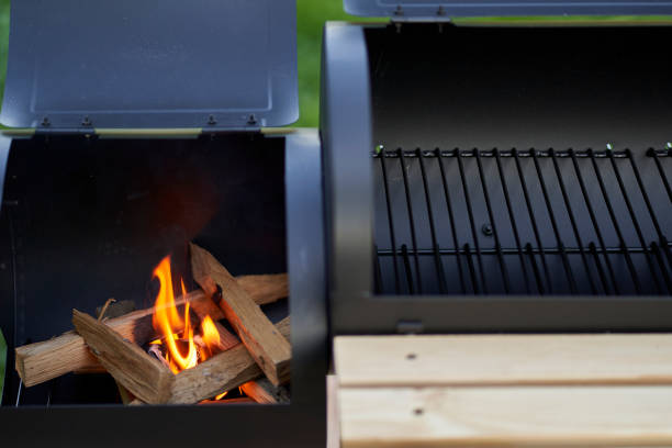 istock New smoker barbecue grill. Stack wood and light it properly. Blazing flames. Closeup. 1407381613