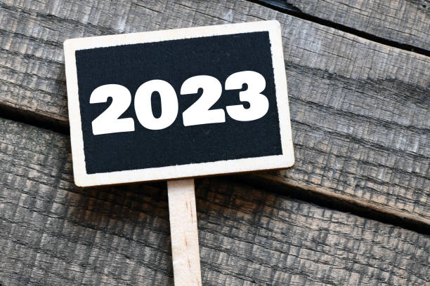 istock 2023 year on a small chalk board and a wooden background. 1407381736