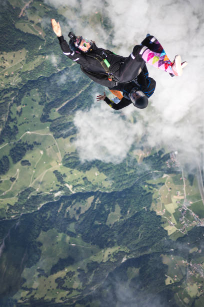 istock Skydivers fall through clear skies, aerial flight 1407381861