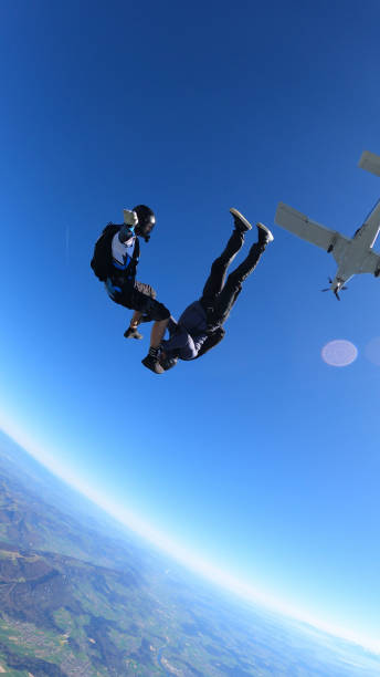 istock Skydivers fall through clear skies, out of airplane 1407381868