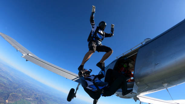 istock Skydivers fall through clear skies, out of airplane 1407381872