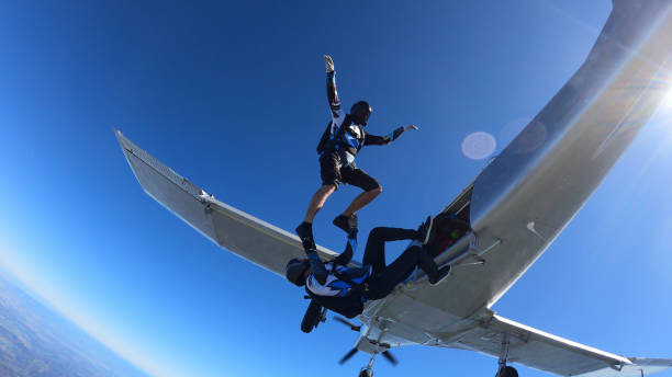 istock Skydivers fall through clear skies, out of airplane 1407381873