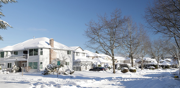 Family homes line a residential street in Surrey, British Columbia. Bright winter morning.