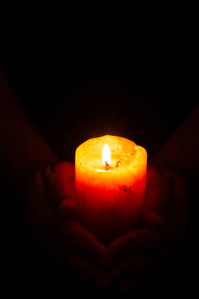 istock A thick candle with light burning in the darkness. 1407384403