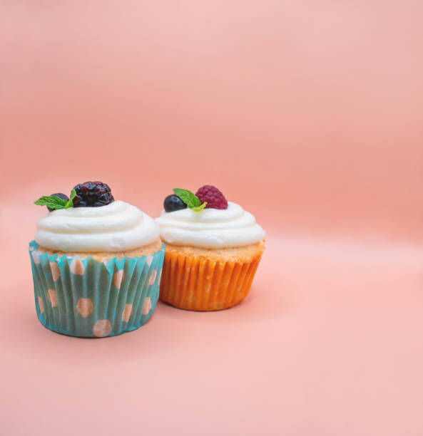 istock Raspberry cupcakes with frosting on a pink background 1407384586