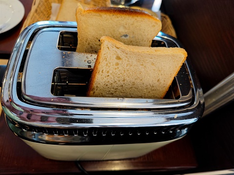 Delicious fresh white bread in a toaster about to be toasted during breakfast. There are no people or trademarks in the shot.
