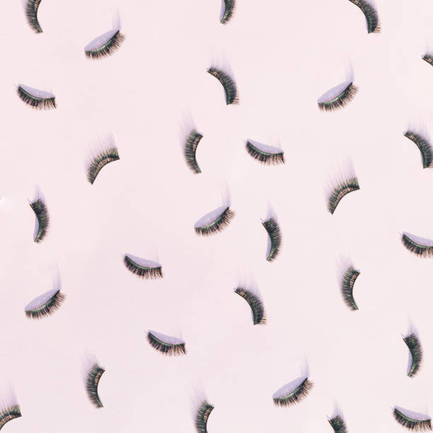 istock Pattern made of black false eyelashes on a pink background. 1407386298