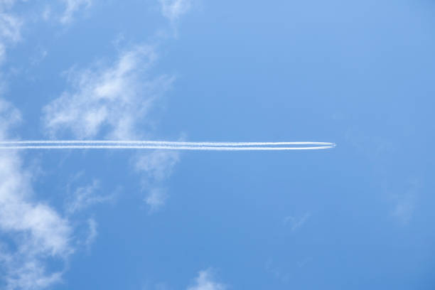 Airplane In Blue Clear Sky With Plane Trails.