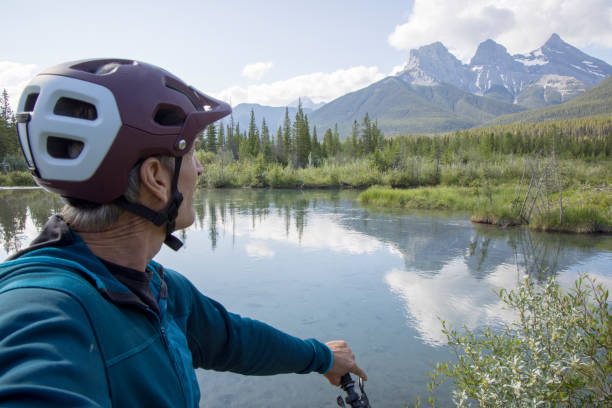 pov de mountain biker sênior faz uma pausa em um lago nas montanhas - self reflection - fotografias e filmes do acervo