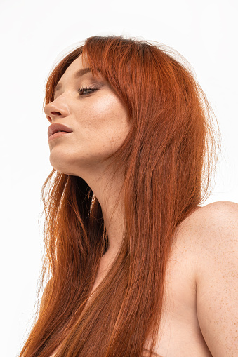 Natural ginger woman with long hair and freckles. Beauty portrait. Studio shot.