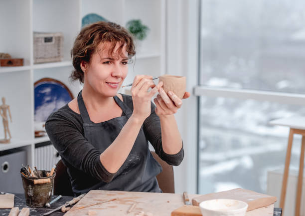 istock Smiling woman potter working at workshop 1407393053