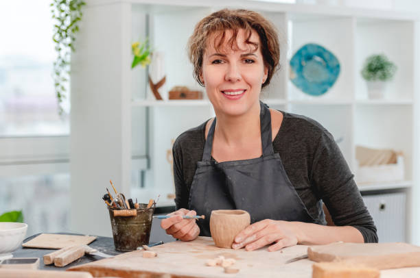 istock Smiling woman potter working at workshop 1407393057