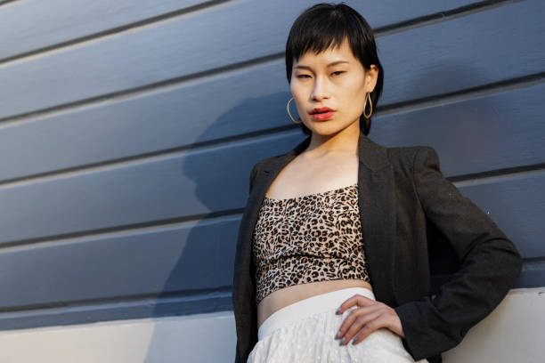 Beautiful, young Asian woman posing against black background. Cool attitude and confidence.