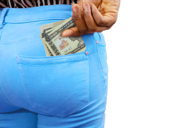 istock Black lady putting few 100 Eritrean nakfa notes into her back pocket. Removing money from pocket, hold money 1407396189