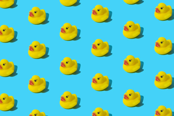 istock Yellow rubber toy duck on a blue background. Pattern. 1407397051