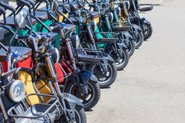 istock Multicolored electric bikes with headlights and baskets stand in a row on a sunny day. Walking rental for tourists. 1407397201