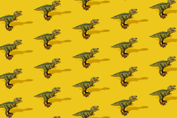 istock Dinosaurs Tyrannosaurus rex on a yellow background. Pattern. T-rex toy. 1407397269