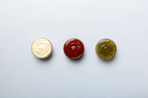 istock Different types of sauces in bowls on a colored Board . Top view. various sauces copy space 1407399649