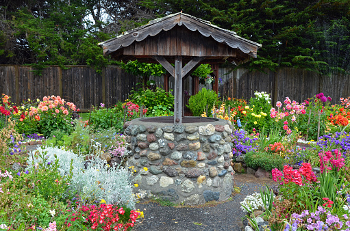 Old brick wishing well in colorful dahlia garden