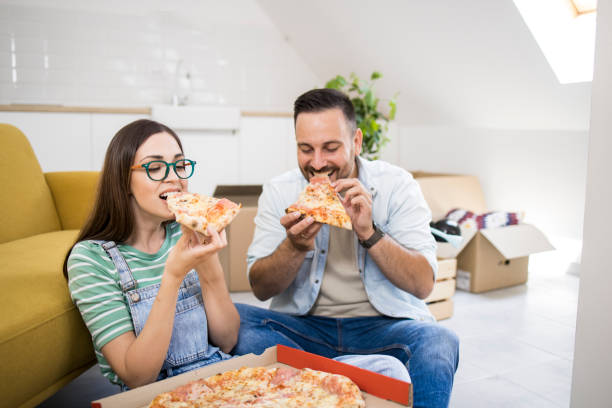 istock Young couple taking a pizza break while moving in 1407408781