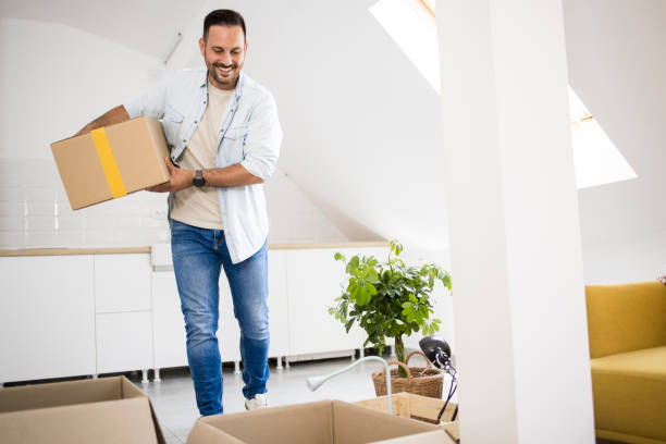 istock Young man bringing boxes with belongings into his new apartment 1407408840
