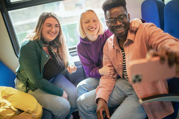istock A smiling group of people take a selfie photo while riding a bus. 1407409202