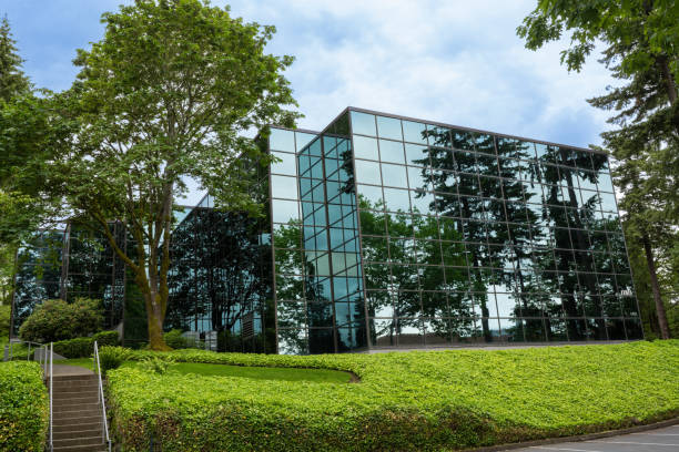 istock Glass Building blends into nature with reflection of sky and trees. 1407417063